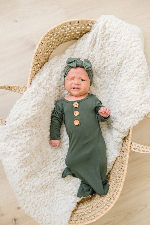 Baby Wearing Luna Luz Knotted Gown and Bow Headband in Olive